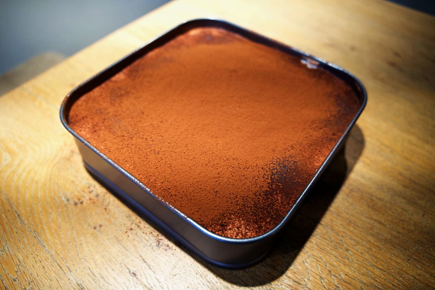 Sharing Slab - Classic — cocoa-dusted tiramisu photographed on a wooden table.
